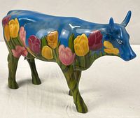Full left side view of blue cow with tulip artwork