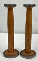 Front view of both wooden spools standing upright
