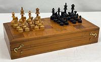 Folded wooden chess board with pieces displayed