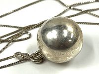 Close view of sterling silver spherical pendant on chain