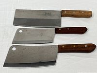 Three cleavers laid out showing fronts, size comparison