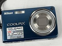 Front view of blue Nikon Coolpix S550 showing lens, 10 MP, VR, 5× zoom specs