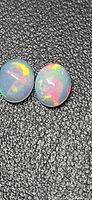 Both opals showing play of color on textured background