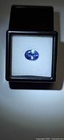 Oval violet-blue tanzanite in gem box under light
