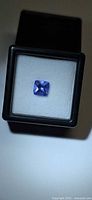Front view of square violet-blue tanzanite in display box