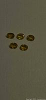 Five oval yellow sapphires on neutral background