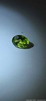 Top view of oval peridot showing color and cut