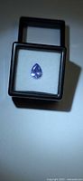 Pear cut tanzanite displayed in gem box under light