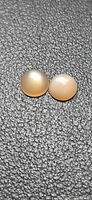 Pair of round peach moonstones on textured background
