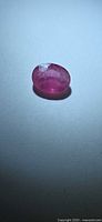 Oval pink sapphire on neutral background, top view