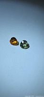 Yellow-orange and green heart-cut sapphires side by side