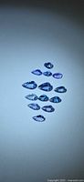 Group of 12 pear-cut tanzanite stones on light background