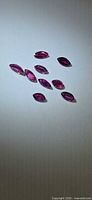 Group of 9 marquise-cut rubies on light background