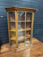 Front angled view of wooden curio cabinet with glass panels and doors closed
