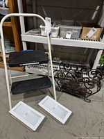 Overall view showing ladder, two packaged floor registers, and wrought iron magazine rack