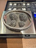 Bracelet and four earrings front view on scale