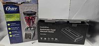 Boxed Oster blender beside boxed HadinEEon vacuum sealer