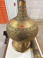 Bulbous perforated brass base and part of cylindrical section