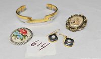 Full group shot: cuff bracelet, two brooches, earrings pair