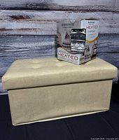 Ottoman with boxed heated throw displayed on top