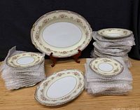 Full lot showing stacked bubble-wrapped plates, bowls and two platters