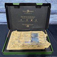 Open box showing board outline, tools and coaster in packaging