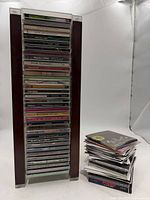 Full view of CD tower filled with discs and separate stack of additional CDs