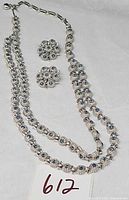 Full view of necklace and both earrings showing design and rhinestone color