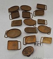 All sixteen brass buckles assorted shapes on white surface