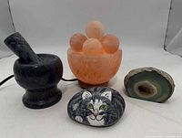 Group shot showing salt lamp, marble mortar & pestle, agate geode slice, painted cat stone