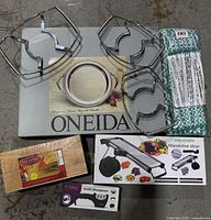 Overall lot with Oneida tray box, three metal holders, mandoline slicer box, knife sharpener box, cedar planks, drying mat