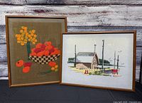 Both framed needlework pieces side by side