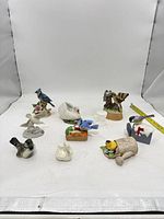 Group shot of all ten bird figurines with measuring tape for scale