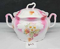 Front view of handled lidded porcelain bowl showing pink accents and floral fruit design