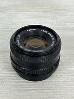 Front angled view of Canon FD 50mm f/1.8 lens showing branding and glass condition