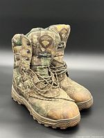 Front and side view of both boots showing camo uppers, laces, logo patch and overall wear