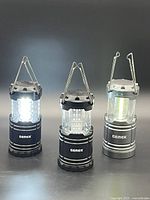 Front view of three illuminated Gemek LED lanterns