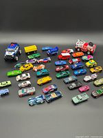 Overview of entire lot of toy cars, trucks, trailer and police SUV