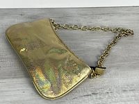 Front view of metallic gold-tone faux snakeskin handbag with chain strap
