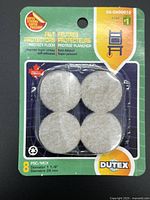 Front view of sealed Dutex felt protectors package showing four visible pads and product details