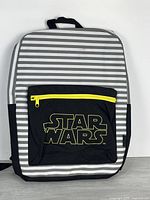 Front view showing striped pattern, logo pocket, yellow zipper