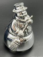 Front view of silver-tone wind-up musical snowman ornament