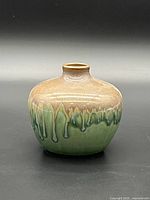 Front view of small brown and green drip-glazed ceramic vase