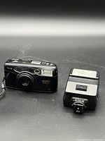 Canon point-and-shoot film camera and Canon flash side by side