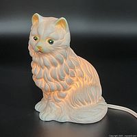 Front three-quarter view of ceramic cat lamp lit