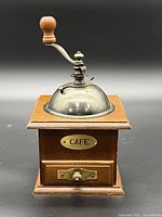 Front view showing wood box, metal dome, crank and "CAFE" plaque