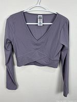 Front of mauve Gymshark cropped V-neck long-sleeve top on hanger