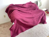 Burgundy electric blanket spread on surface