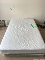 Top view of full mattress wrapped in plastic on box spring