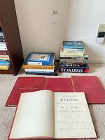 All four red Gilbert & Sullivan vocal scores with one opened to Iolanthe title page, adjacent stacks of additional books visible